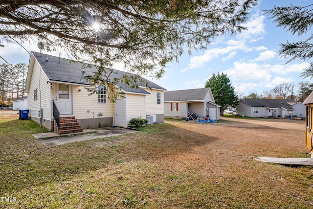 back of property featuring a yard, a garage, and cooling unit