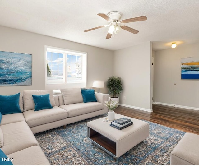 living room featuring ceiling fan, dark hardwood / wood-style flooring, and a textured ceiling