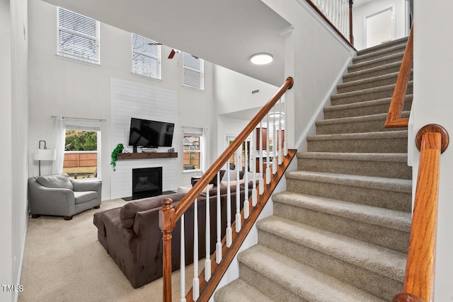 stairs featuring carpet and a high ceiling