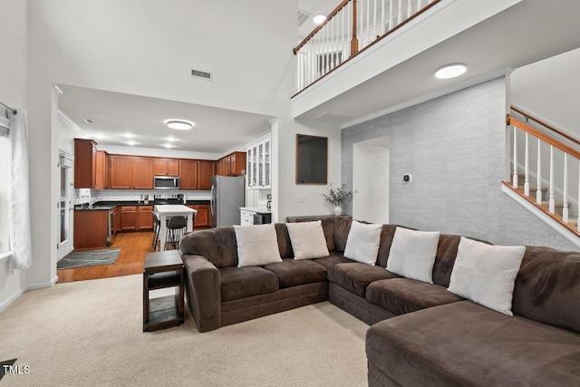 living room featuring a towering ceiling and light colored carpet