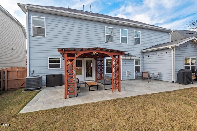 back of house with central AC unit, a patio area, a pergola, and a yard