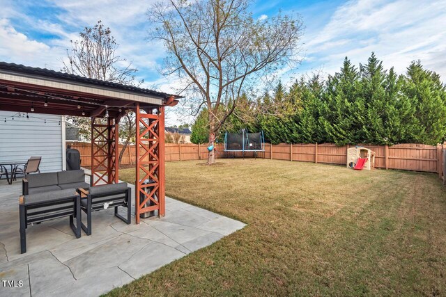 view of yard with a trampoline and a patio area