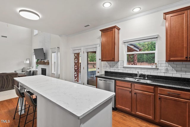 kitchen featuring decorative backsplash, light hardwood / wood-style flooring, a kitchen island, and sink