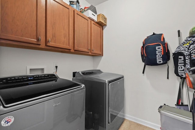 laundry area with washer and clothes dryer and cabinets