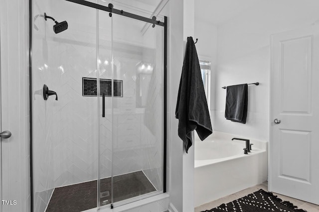 bathroom featuring tile patterned floors and separate shower and tub