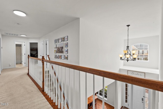 hall featuring a chandelier and light colored carpet