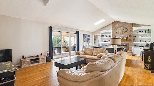 living room with light wood-type flooring, a fireplace, and vaulted ceiling