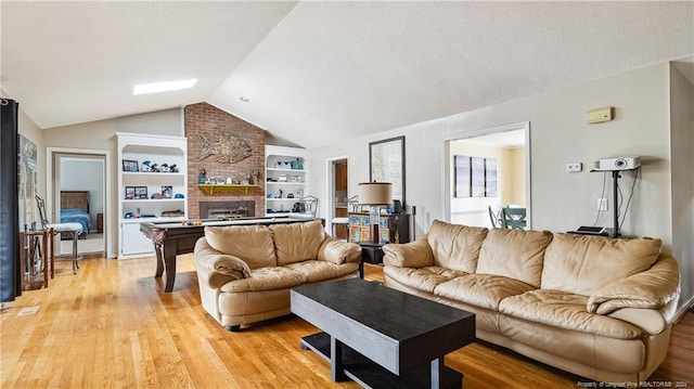 living room with lofted ceiling, light hardwood / wood-style flooring, built in shelves, a fireplace, and pool table