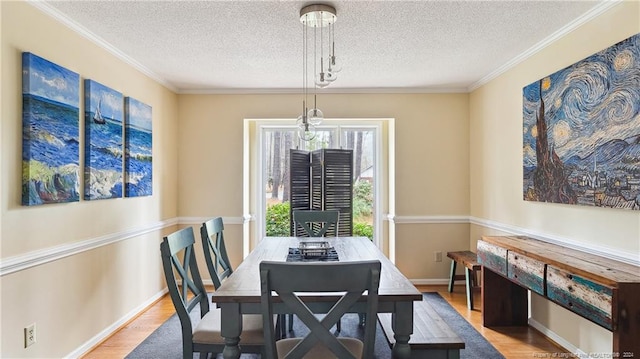 dining area with a textured ceiling, light wood-type flooring, and ornamental molding