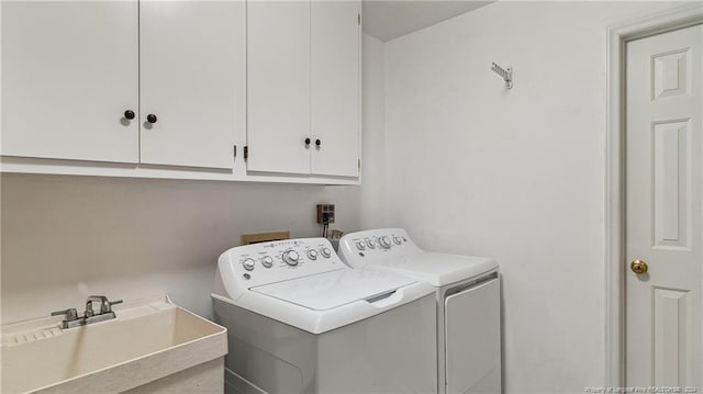 laundry area featuring cabinets, independent washer and dryer, and sink