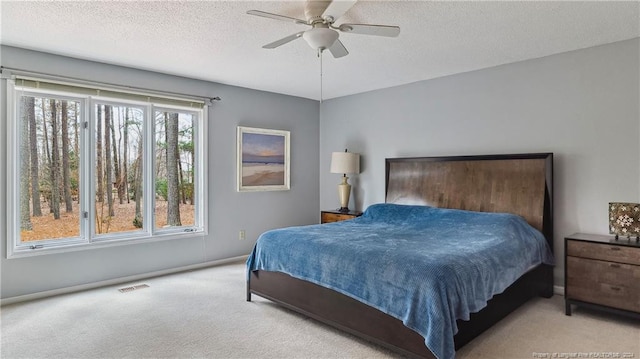 carpeted bedroom featuring a textured ceiling and ceiling fan