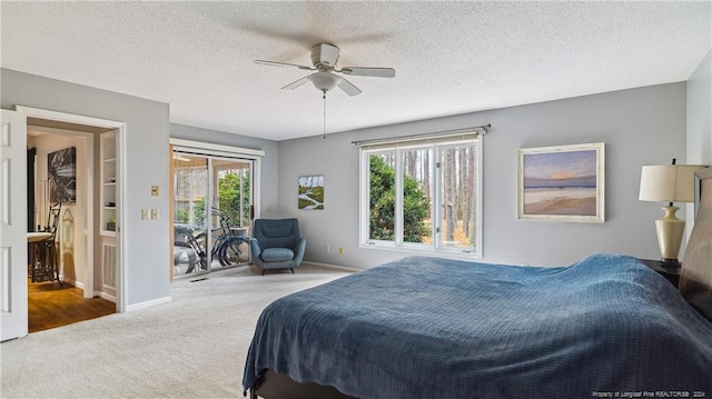 carpeted bedroom featuring access to exterior, a textured ceiling, multiple windows, and ceiling fan