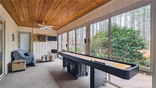 recreation room featuring carpet flooring, ceiling fan, wood ceiling, and wood walls