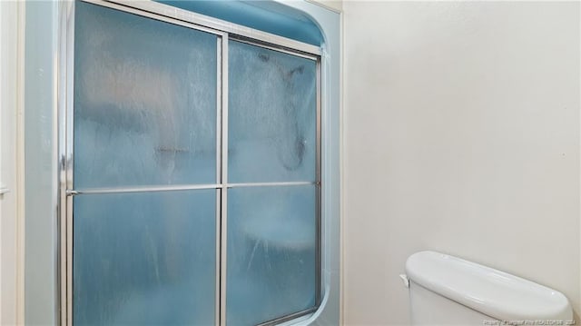 bathroom with toilet and walk in shower