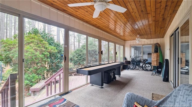 sunroom / solarium with ceiling fan, a healthy amount of sunlight, and wood ceiling