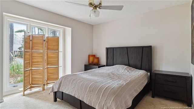 bedroom with ceiling fan and light colored carpet