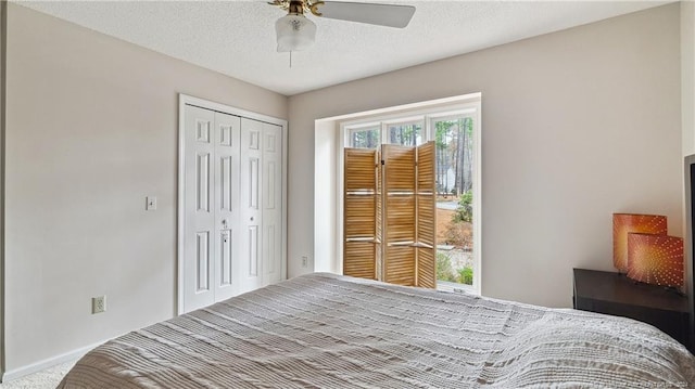 bedroom featuring ceiling fan, a closet, carpet floors, and a textured ceiling