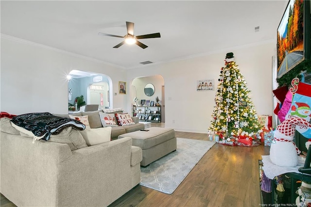 living room with hardwood / wood-style flooring, ceiling fan, and crown molding