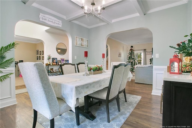 dining room featuring dark hardwood / wood-style flooring, ornamental molding, and an inviting chandelier