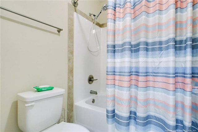 bathroom featuring shower / tub combo and toilet