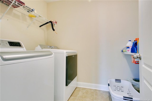 laundry room with washer and dryer and light tile patterned flooring