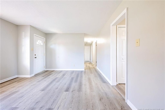 interior space with light wood-type flooring and a textured ceiling