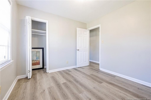 unfurnished bedroom featuring a closet and light wood-type flooring