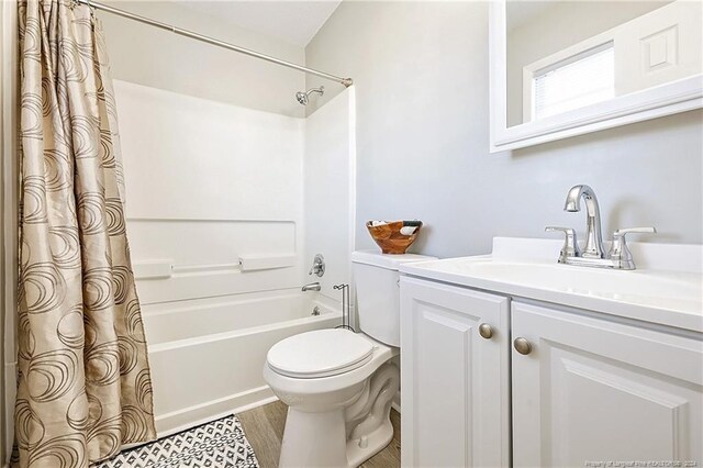 full bathroom featuring vanity, toilet, wood-type flooring, and shower / tub combo