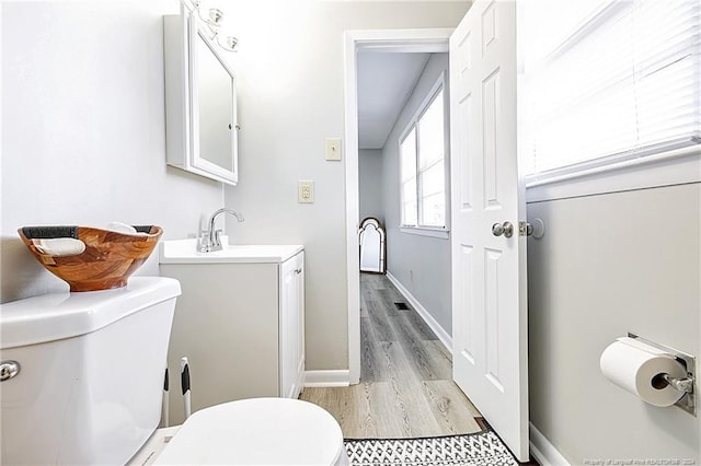 bathroom featuring vanity, toilet, and wood-type flooring