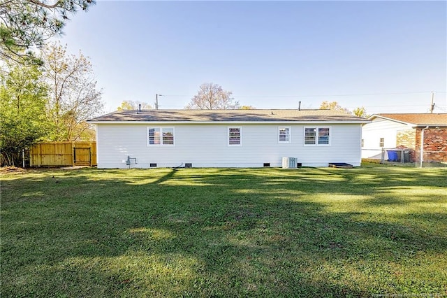 rear view of house with a lawn and cooling unit