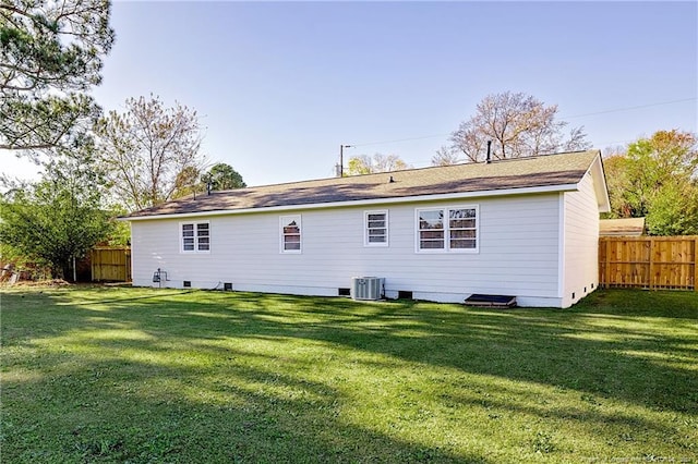 back of house featuring central AC and a yard