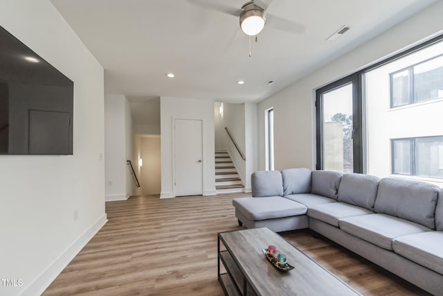 living room with ceiling fan and light hardwood / wood-style flooring