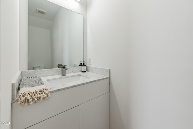 bathroom featuring vanity and toilet