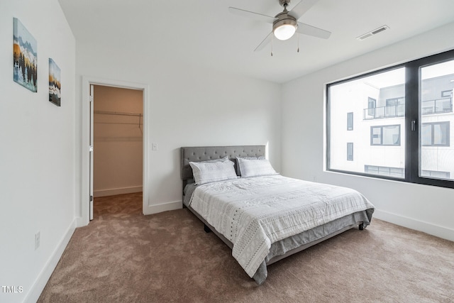 bedroom with carpet floors, a spacious closet, a closet, and ceiling fan