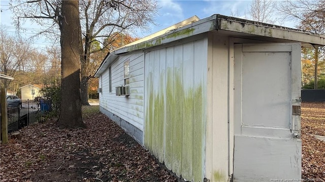 view of side of home with cooling unit and a storage shed