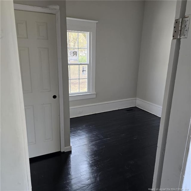 unfurnished room with dark hardwood / wood-style flooring