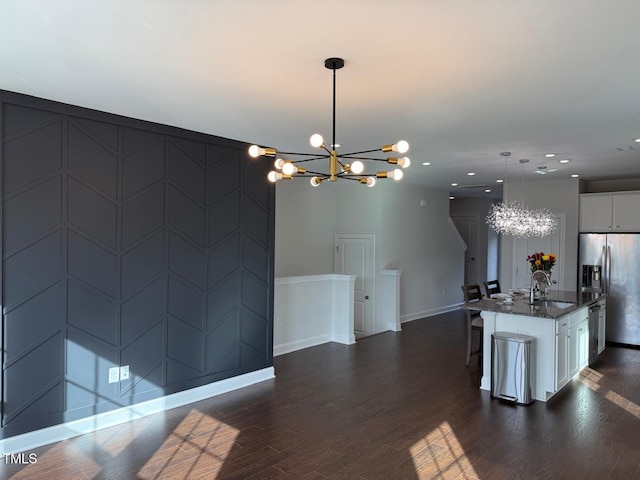 kitchen featuring a kitchen island with sink, white cabinets, decorative light fixtures, and a notable chandelier