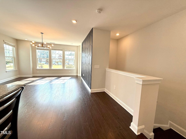 interior space with dark hardwood / wood-style floors, a healthy amount of sunlight, and a notable chandelier