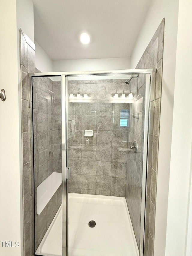 bathroom with a shower with door