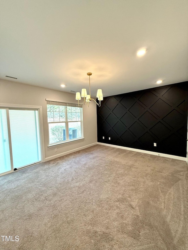 unfurnished room with carpet and a chandelier