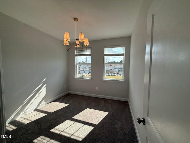 unfurnished room with dark carpet and an inviting chandelier