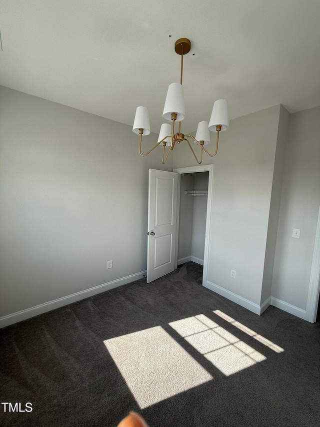 carpeted empty room featuring a chandelier