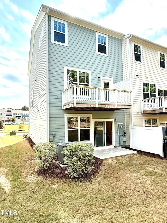 rear view of house featuring a lawn, cooling unit, and a patio