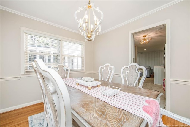 dining area with crown molding, light hardwood / wood-style floors, and a chandelier