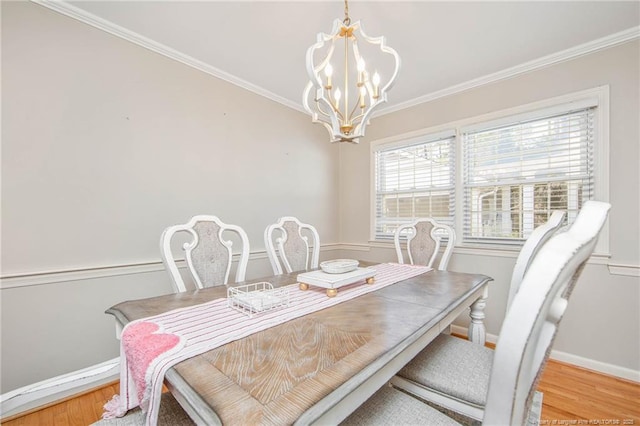 dining room with hardwood / wood-style floors, ornamental molding, and a chandelier