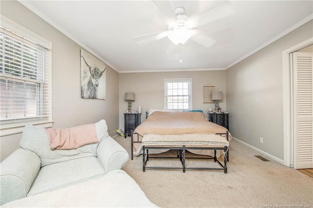 bedroom featuring crown molding, ceiling fan, a closet, and carpet