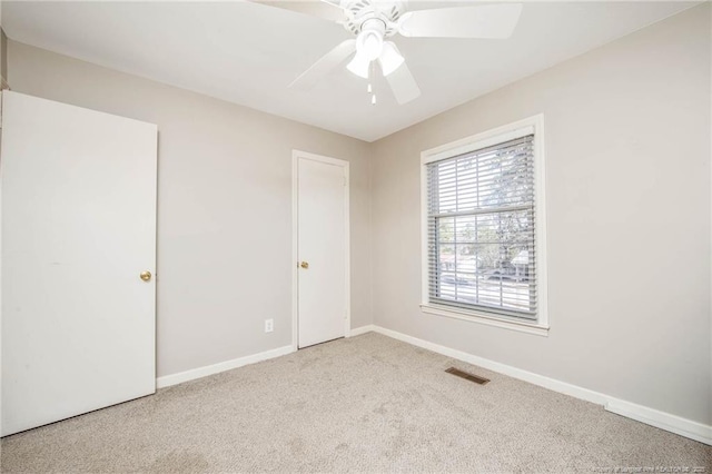 carpeted spare room featuring ceiling fan