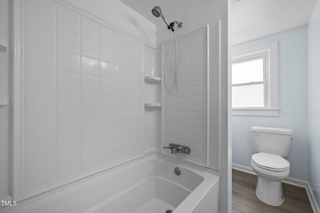 bathroom with hardwood / wood-style floors, tiled shower / bath combo, and toilet