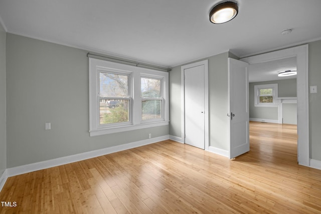 unfurnished bedroom featuring crown molding and light hardwood / wood-style flooring