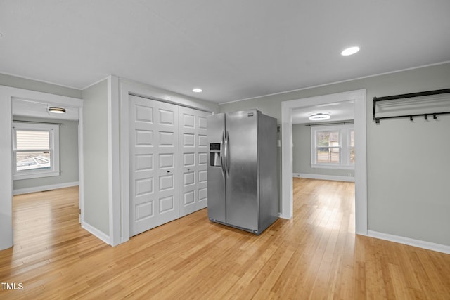 kitchen with a wealth of natural light, stainless steel fridge with ice dispenser, and light hardwood / wood-style floors